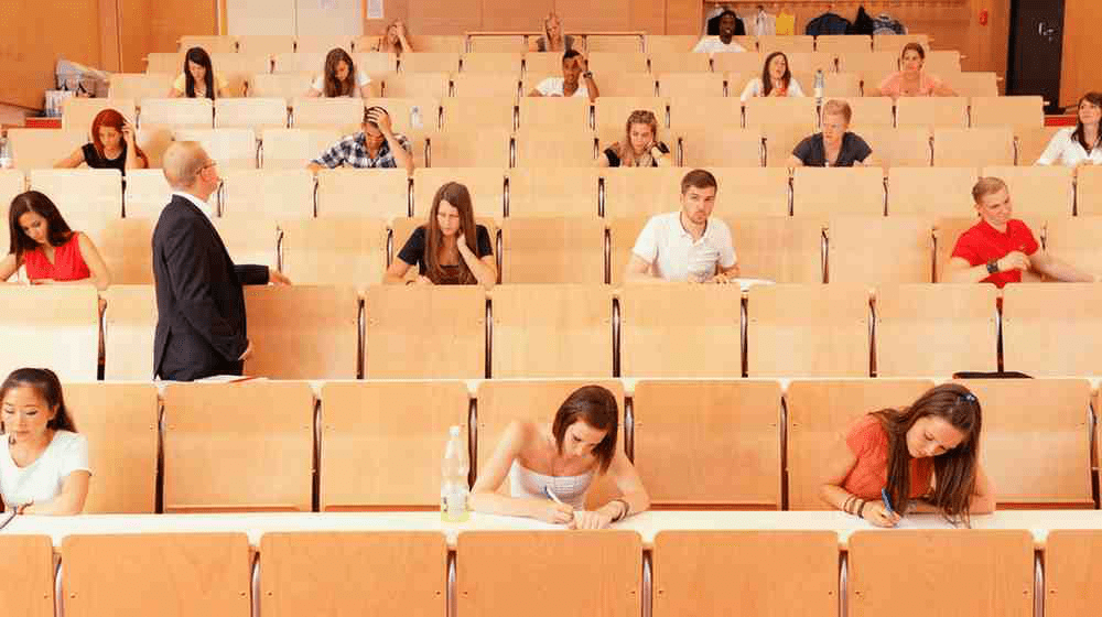 A group of medical school students taking the USMLE Step 2 in a classroom.